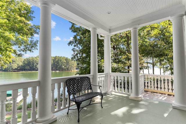 sunroom / solarium featuring a water view and decorative columns