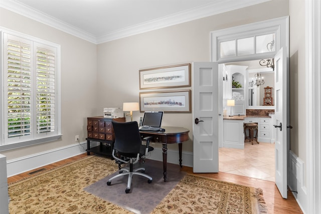 home office with ornamental molding, light wood-type flooring, and an inviting chandelier