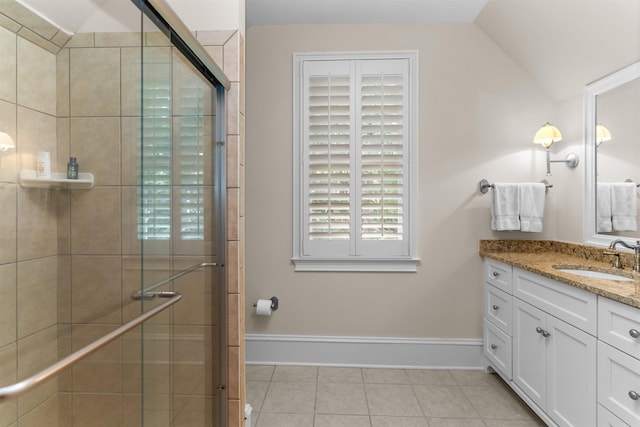 bathroom with vanity, tile patterned flooring, vaulted ceiling, and a shower with shower door