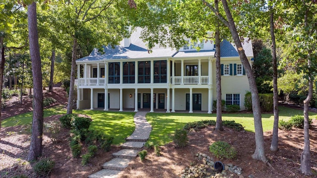 view of front of house with a sunroom and a front lawn