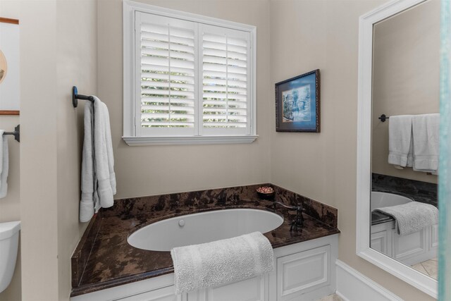 bathroom featuring toilet and a bath