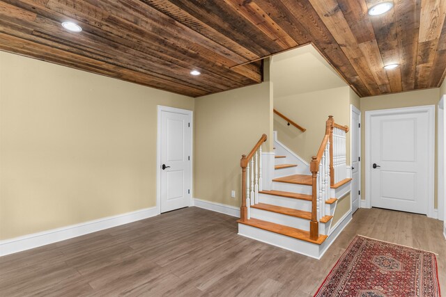 staircase featuring hardwood / wood-style floors and wood ceiling