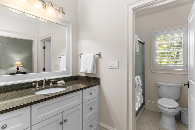 bathroom featuring vanity, a shower with shower door, and toilet