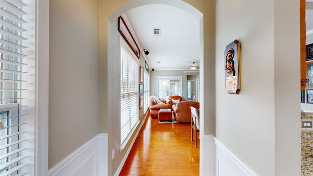 hall featuring ornamental molding and light hardwood / wood-style floors