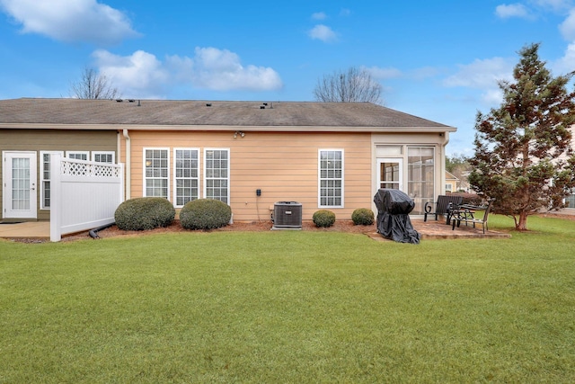 rear view of house featuring a patio, cooling unit, and a lawn