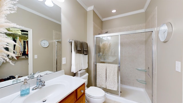 bathroom featuring crown molding, vanity, toilet, and a shower with shower door