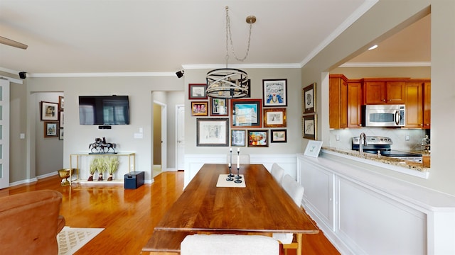 dining area featuring ornamental molding and light hardwood / wood-style floors