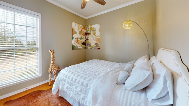 bedroom featuring multiple windows, ornamental molding, hardwood / wood-style floors, and ceiling fan