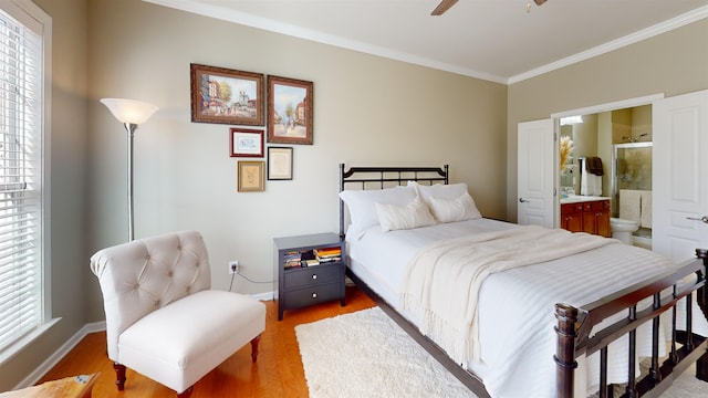 bedroom featuring multiple windows, light hardwood / wood-style flooring, ornamental molding, and ensuite bathroom