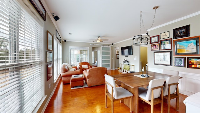 dining area featuring crown molding, ceiling fan, and light hardwood / wood-style flooring