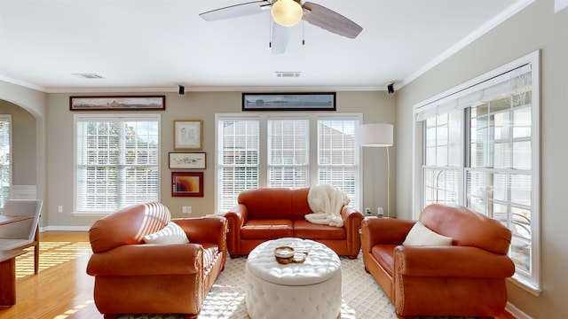 living room featuring crown molding, plenty of natural light, light hardwood / wood-style floors, and ceiling fan