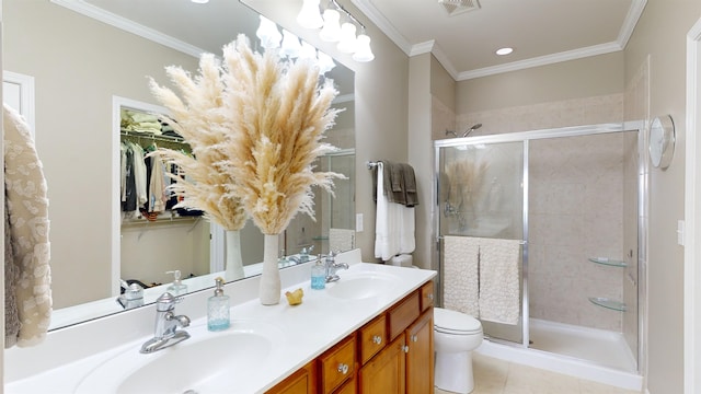 bathroom with a shower with door, vanity, ornamental molding, tile patterned floors, and toilet