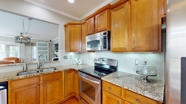 kitchen with sink, crown molding, appliances with stainless steel finishes, light stone counters, and decorative backsplash