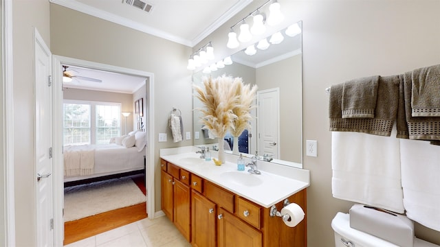 bathroom featuring tile patterned flooring, crown molding, vanity, and toilet