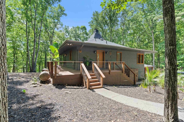 114 Oak Ridge Ln, Eatonton, GA 31024 - view of front facade with brick siding, a wooden deck, stairway, and a chimney