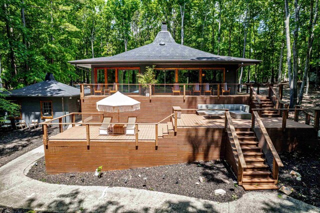 114 Oak Ridge Ln, Eatonton, GA 31024 - rear view of house featuring stairway, a deck, a chimney, and a forest view