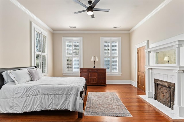 1011 Dogwood Dr, Greensboro, GA 30642 - bedroom with a tile fireplace, wood-type flooring, visible vents, and ornamental molding