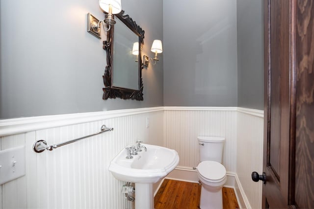 1011 Dogwood Dr, Greensboro, GA 30642 - half bathroom with toilet, a wainscoted wall, and wood finished floors