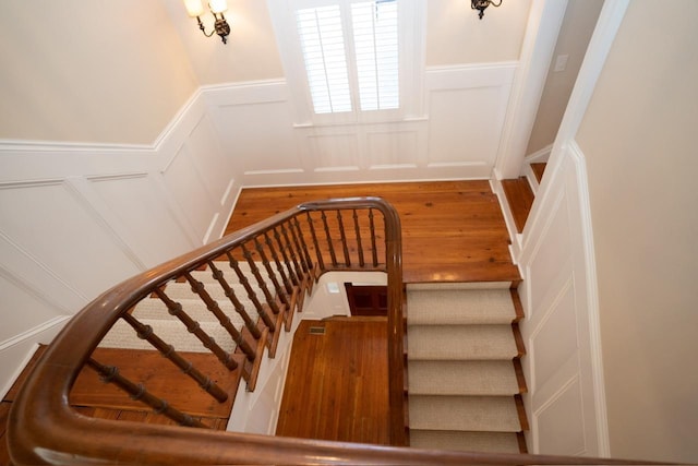 1011 Dogwood Dr, Greensboro, GA 30642 - stairs with a decorative wall, wood finished floors, and wainscoting