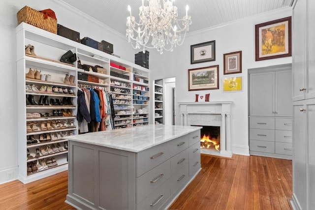 1011 Dogwood Dr, Greensboro, GA 30642 - walk in closet with a notable chandelier, hardwood / wood-style floors, and a lit fireplace