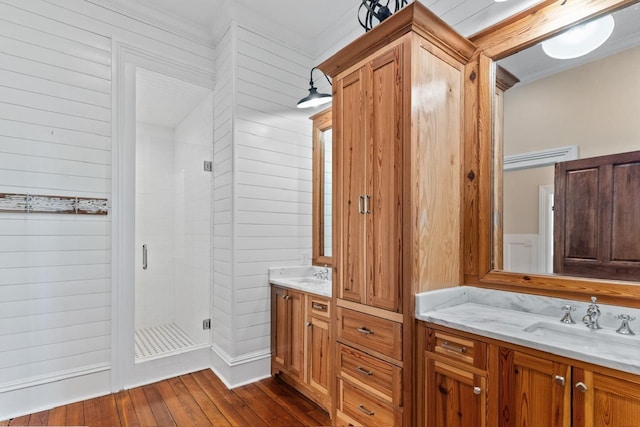 1011 Dogwood Dr, Greensboro, GA 30642 - bathroom featuring a shower stall, vanity, ornamental molding, hardwood / wood-style floors, and wooden walls