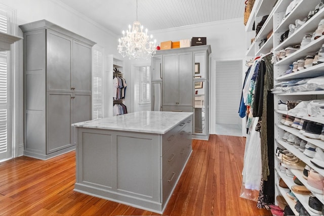 1011 Dogwood Dr, Greensboro, GA 30642 - walk in closet featuring light wood-type flooring and an inviting chandelier