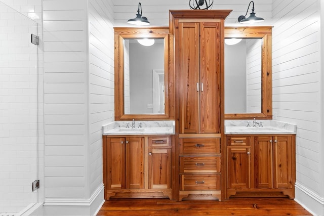 1011 Dogwood Dr, Greensboro, GA 30642 - full bathroom featuring a sink, double vanity, wood finished floors, wood walls, and a stall shower