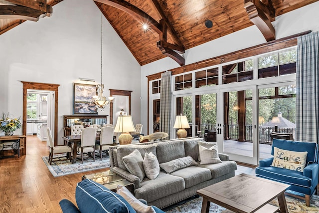 living room featuring wood ceiling, light hardwood / wood-style flooring, beam ceiling, high vaulted ceiling, and a notable chandelier