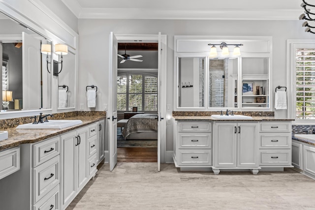 bathroom featuring ceiling fan, ornamental molding, hardwood / wood-style floors, and vanity