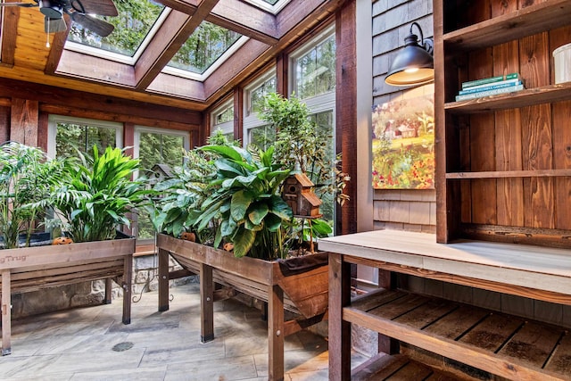 sunroom / solarium featuring ceiling fan and a skylight