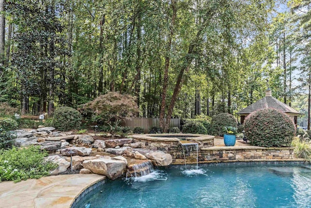 view of swimming pool featuring an in ground hot tub and pool water feature