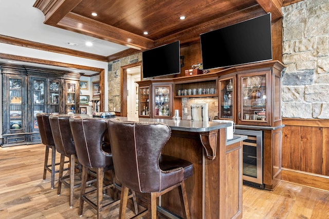 bar with wood ceiling, beam ceiling, ornamental molding, beverage cooler, and light wood-type flooring