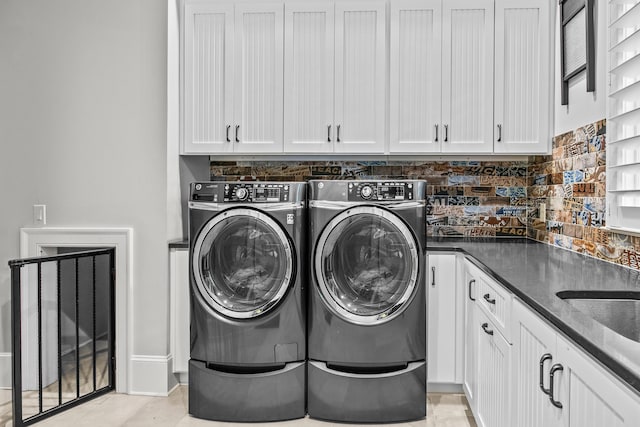 laundry area featuring cabinets, separate washer and dryer, and light tile patterned floors