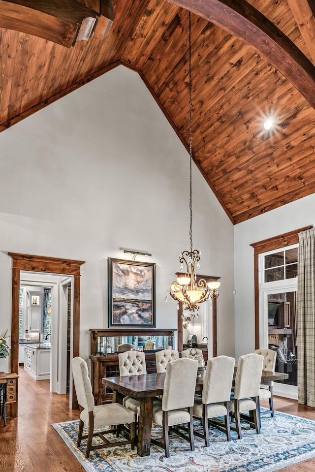 dining space featuring hardwood / wood-style flooring, an inviting chandelier, wooden ceiling, and high vaulted ceiling