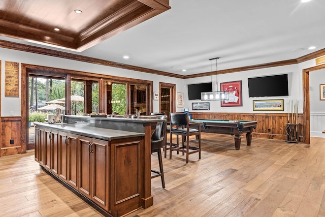 kitchen with crown molding, a center island, hanging light fixtures, and light wood-type flooring