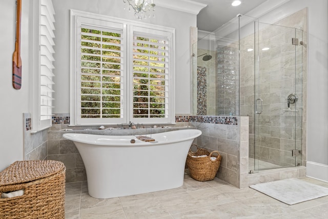 bathroom with ornamental molding, separate shower and tub, tile walls, and a notable chandelier