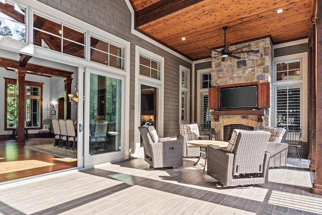 deck with ceiling fan and an outdoor stone fireplace