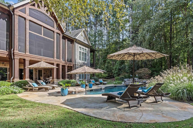 view of swimming pool featuring a patio and a sunroom