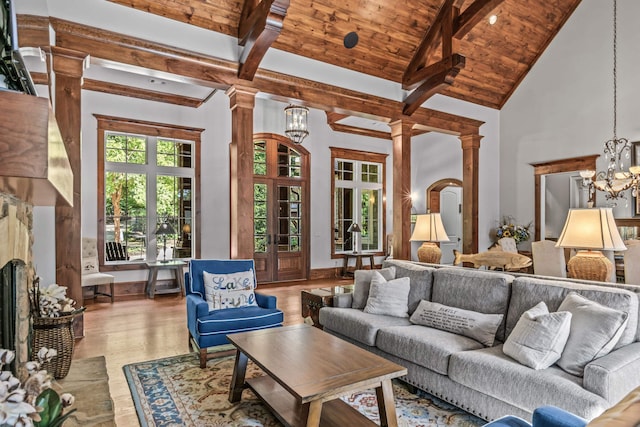 living room featuring a notable chandelier, beam ceiling, high vaulted ceiling, and light wood-type flooring