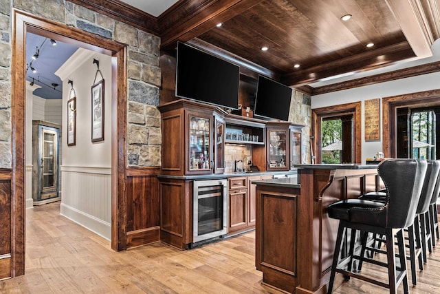 bar featuring beam ceiling, crown molding, wood ceiling, light wood-type flooring, and beverage cooler