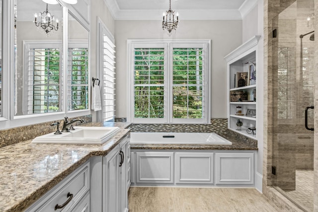 bathroom with an inviting chandelier, vanity, crown molding, and separate shower and tub