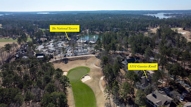 birds eye view of property featuring a water view, a wooded view, and golf course view