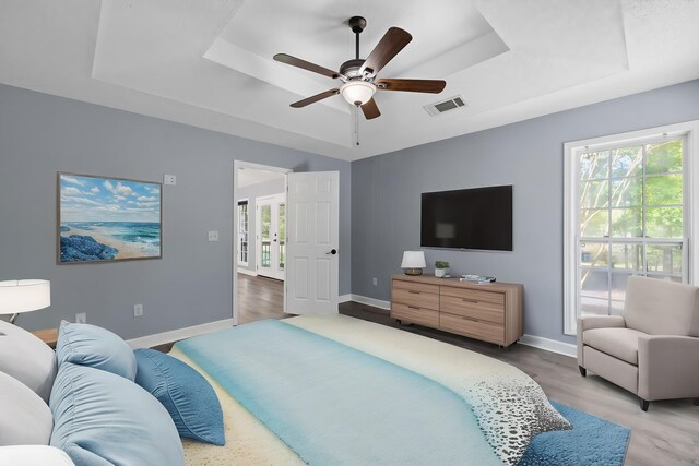 348 Bluegill Rd, Eatonton, GA 31024 - bedroom featuring a tray ceiling, baseboards, multiple windows, and visible vents