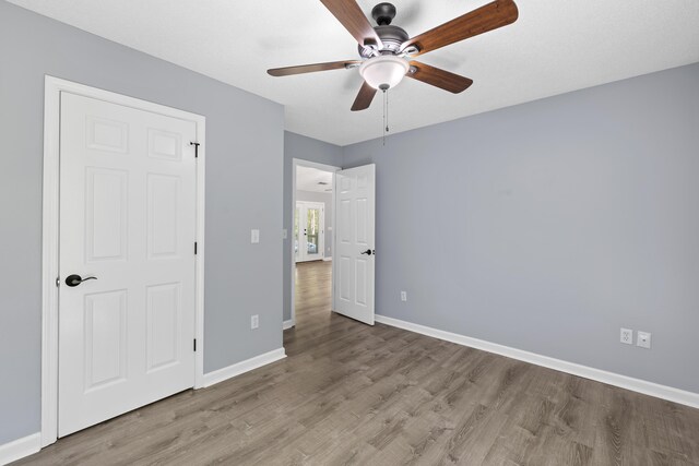 348 Bluegill Rd, Eatonton, GA 31024 - unfurnished bedroom featuring baseboards, a ceiling fan, and wood finished floors