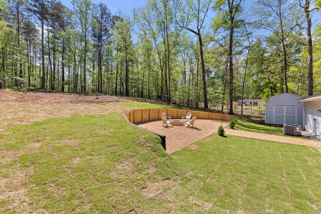 348 Bluegill Rd, Eatonton, GA 31024 - view of yard featuring an outbuilding, a storage shed, central air condition unit, an outdoor fire pit, and a patio area