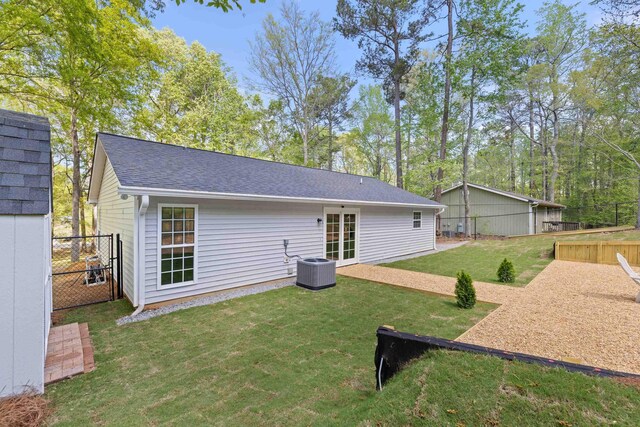 348 Bluegill Rd, Eatonton, GA 31024 - back of house with central AC, fence, roof with shingles, and a lawn