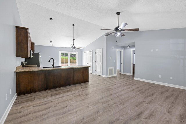 348 Bluegill Rd, Eatonton, GA 31024 - kitchen with a sink, open floor plan, a ceiling fan, dark brown cabinetry, and a peninsula