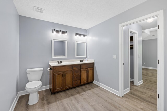 348 Bluegill Rd, Eatonton, GA 31024 - bathroom featuring a sink, visible vents, toilet, and wood finished floors