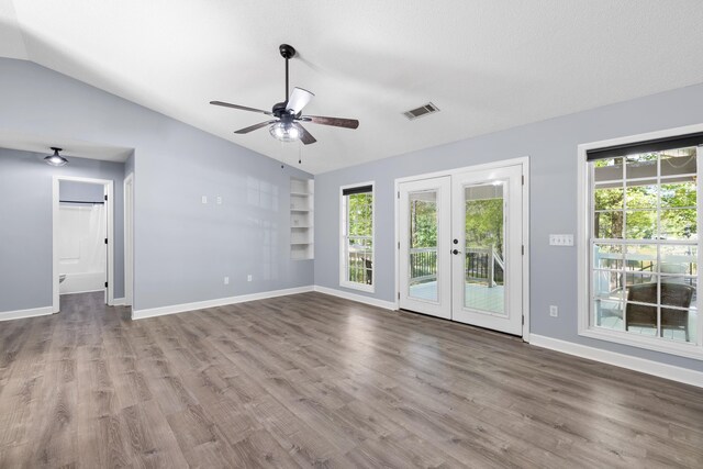 348 Bluegill Rd, Eatonton, GA 31024 - unfurnished living room with visible vents, built in features, wood finished floors, vaulted ceiling, and french doors