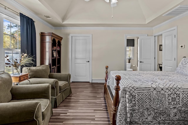 bedroom featuring a baseboard heating unit, wood-type flooring, ornamental molding, and a raised ceiling